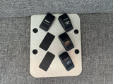 RV rental switch panel: Awning, shower, shower vent, and cell booster controls mounted on a gray fabric surface.