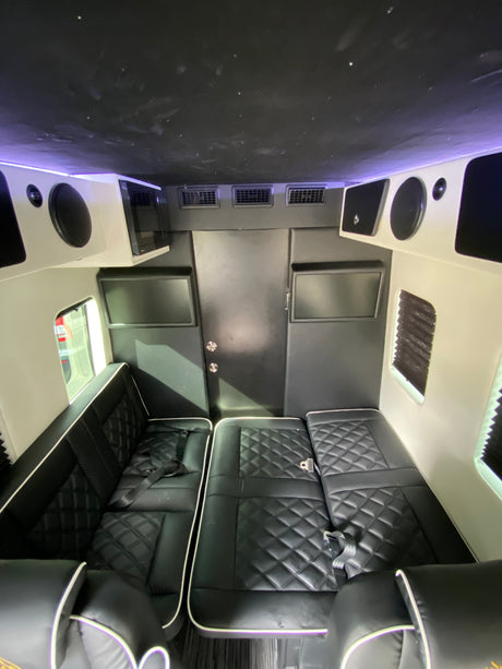 Spacious, luxury RV rental interior with black quilted seating, starry ceiling, and entertainment. Perfect for travel comfort.