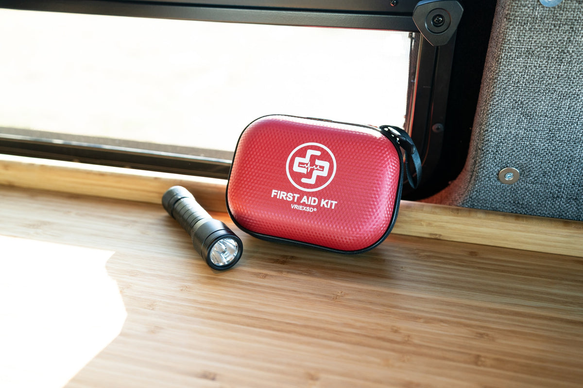 Stay safe in your rv rental with essential items: a red first aid kit and flashlight on a wooden counter. — photo 17