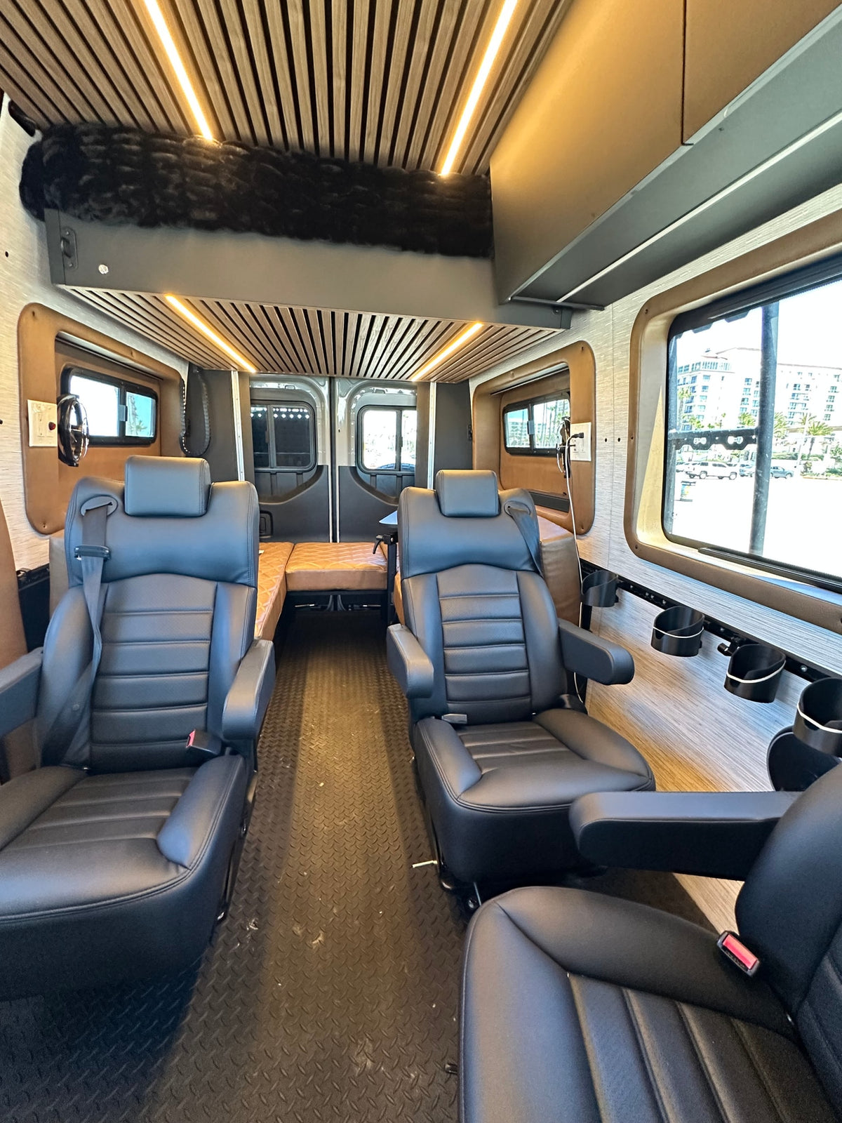  often an rv rental. Side door open reveals custom interior. Parked by palm trees.|Grey Mercedes Sprinter adventure RV rental camper van with off-road tires — photo 6