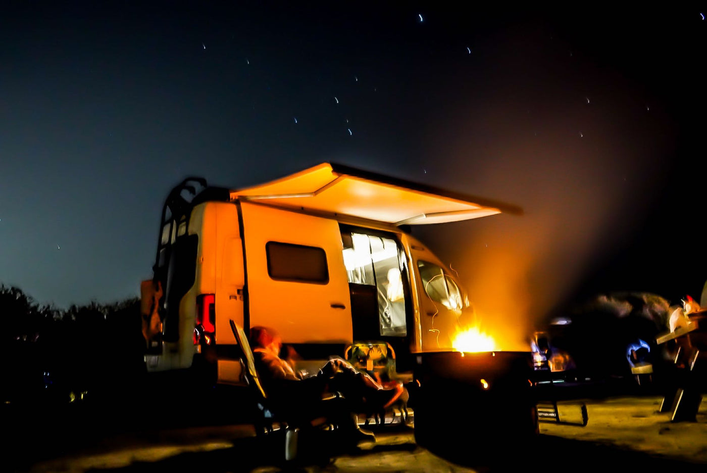  and utility hookups.|A serene ocean view from inside an RV rental. A patterned blanket covers the bed — photo 11