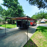 Explore with this overland camper and its attached awning, towed by a red truck in a driveway. Perfect for your RV rental adventures!