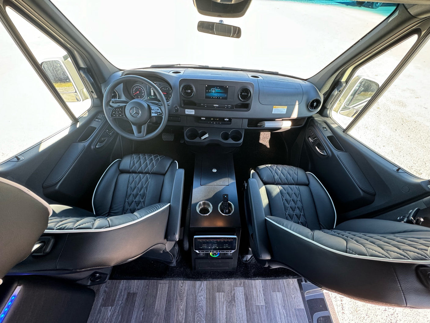 RV rental interior: Premium cockpit with modern dashboard, black quilted seats, and spacious design.