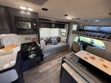 Cozy rv rental interior with kitchen, living, and bunk bed areas, ready for camping adventures by the water.