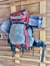 Traveler's backpack & blankets hung on wooden RV rental walls. Smart storage for your next adventure trip.