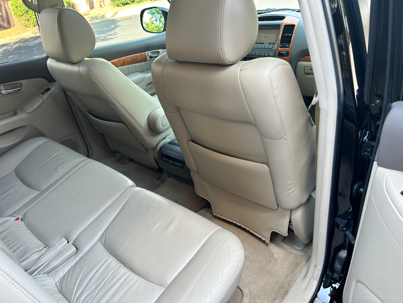 Inside view of a roomy SUV, featuring light leather rear seats and dashboard controls, ideal for your next rv rental adventure.