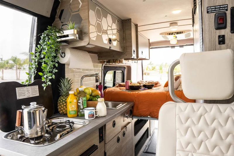  with a 'VANLIFE' sign. Perfect for your next rv rental adventure.|Cozy RV rental interior with a non-alcoholic beer — photo 2