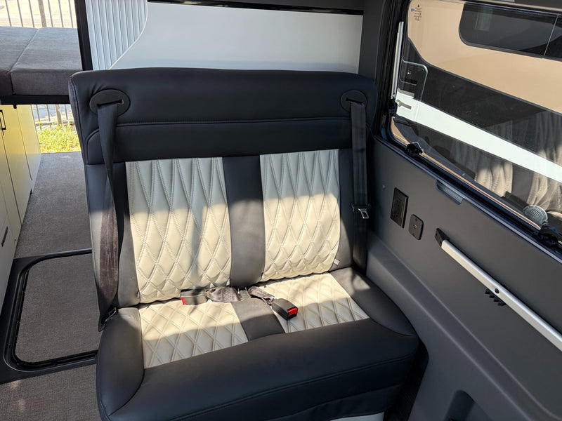  plus comfy passenger seating.|Dark gray pop-top camper van with a "SOLD" sign. An ideal RV for future rv rental trips — photo 9