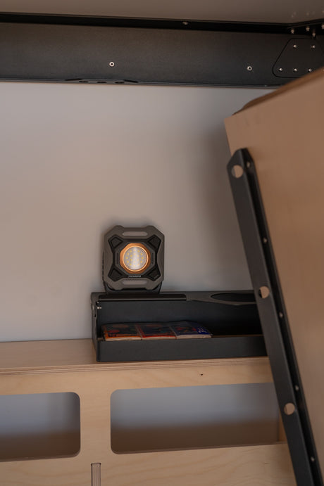 Inside an **RV rental**: a Duracell LED work light illuminating integrated storage and a cleverly designed convertible bed system.