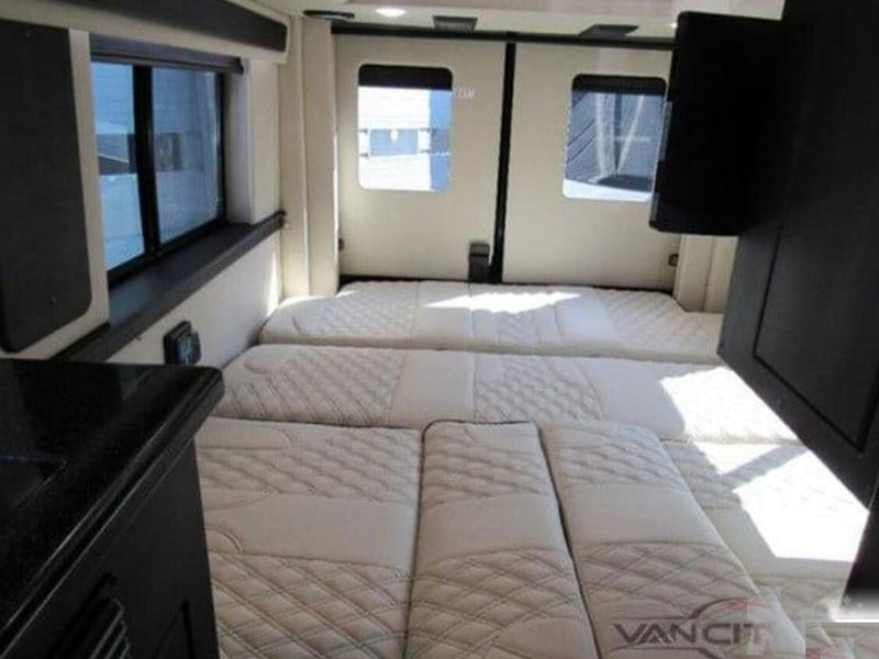  easily converting for living or sleeping.|Modern luxury RV rental interior with a large TV — photo 14