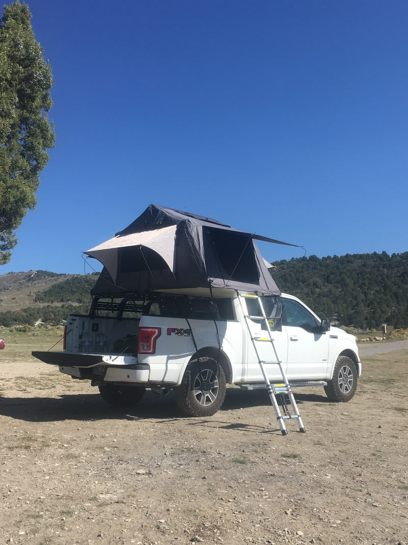 A white Ford F-150 pickup with rooftop tent setup, a great 'RV rental' alternative for rugged outdoor camping. — photo 5