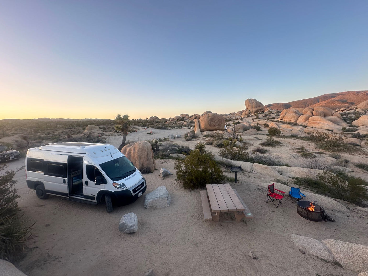 RV rental adventure: Desert camping with a camper van, campfire, and stunning rock formations.