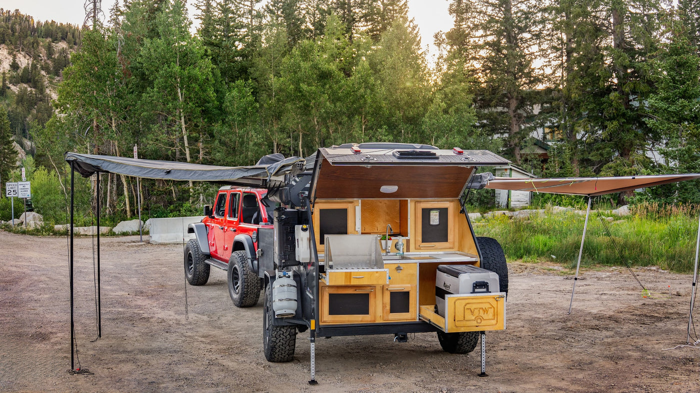Ready for adventure: a red Jeep and an equipped off-road rv rental teardrop trailer with outdoor kitchen and awnings extended. — photo 8