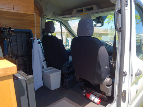 Step inside your next RV rental: comfy seats, ample cab space, and essential safety gear like a fire extinguisher.