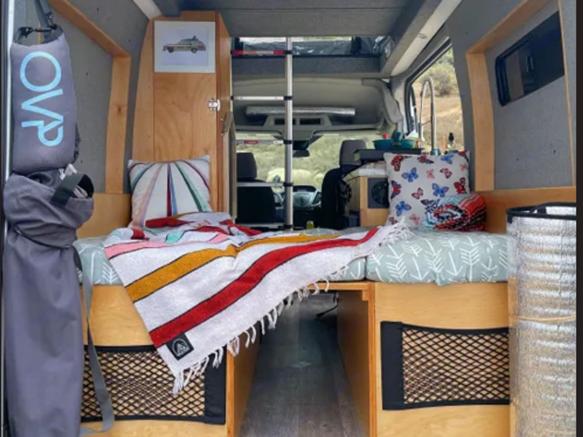  ready for any adventure.|Compact RV rental interior featuring an open storage cabinet with kitchen items & towels — photo 9