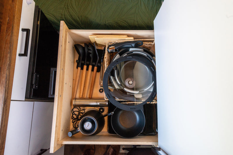 Inside an RV rental's well-organized kitchen drawer: compact cooking utensils, stackable pots/pans, and a thermometer. — photo 17