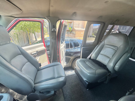 Spacious rv rental interior featuring grey swivel seats and open doors, revealing an outdoor scene.