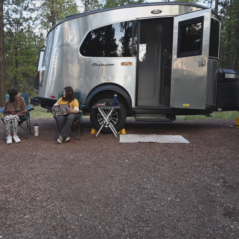 Two people lounge by their Airstream RV rental, embracing outdoor travel. A perfect setup for a relaxing camping trip. — photo 15