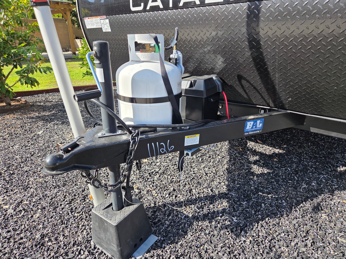 RV rental front hitch with propane tank, battery, and serial 11126, ready for travel.
