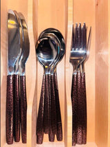 Shiny cutlery set with unique textured handles in a wooden organizer, ideal for an RV rental kitchen.