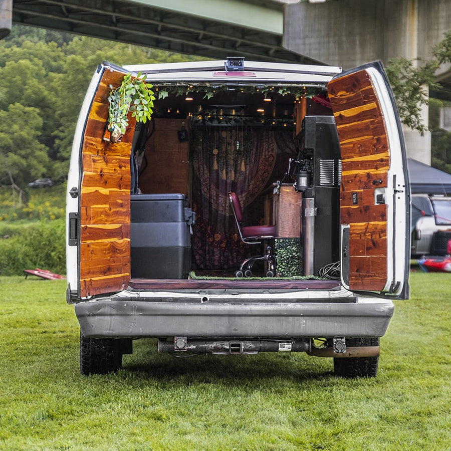  and warm wooden interior with string lights for cozy travel.|This RV rental's cozy interior features floral bench seating