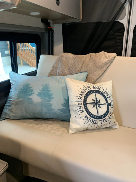 Cozy RV rental interior with pillows and blanket on a comfortable sofa, perfect for your next adventure.