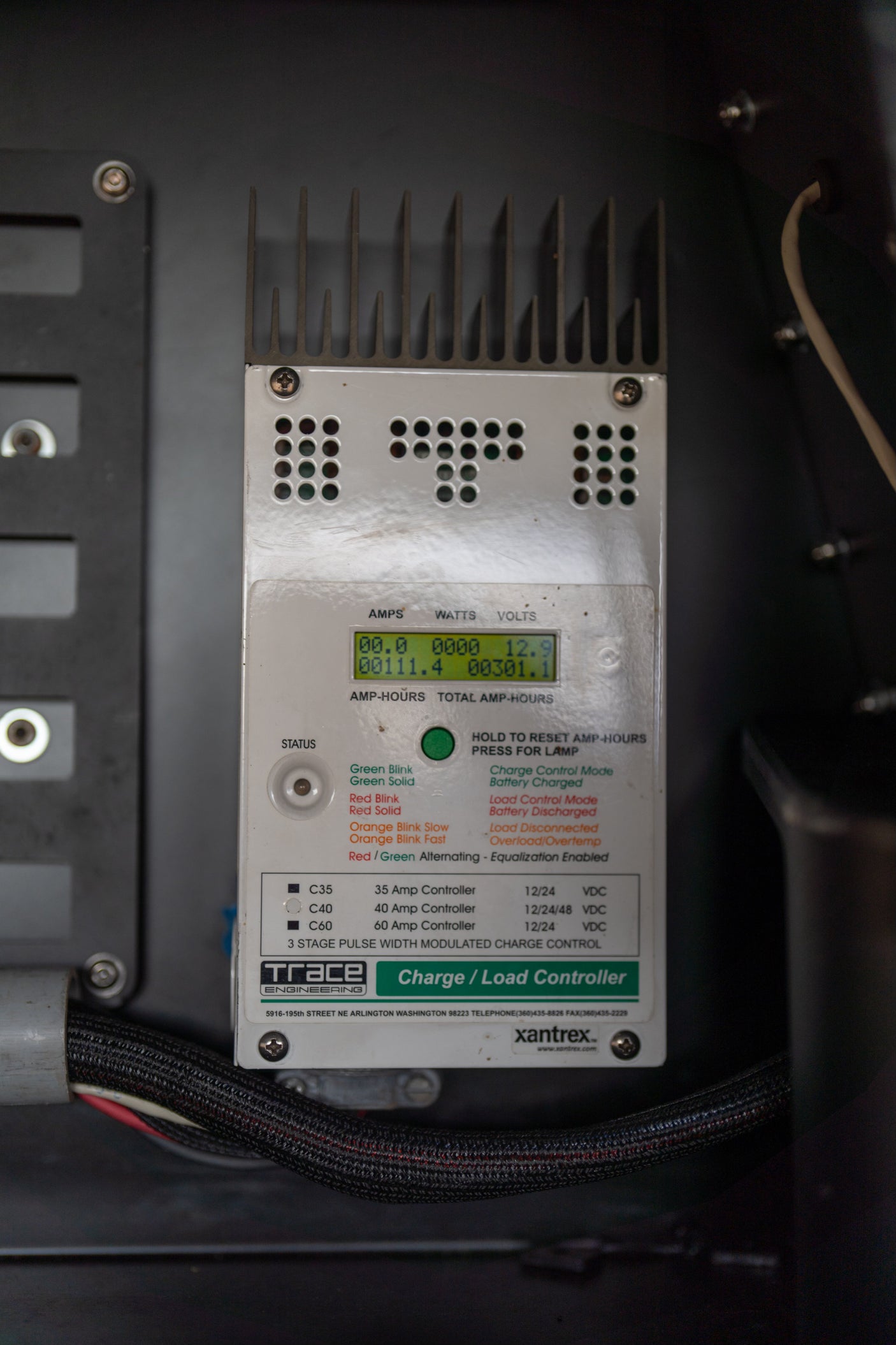 Charge controller in an RV rental displaying electrical stats like volts and amp-hours.