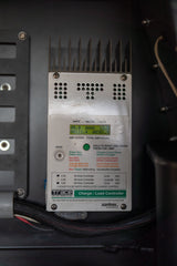 Charge controller in an RV rental displaying electrical stats like volts and amp-hours.