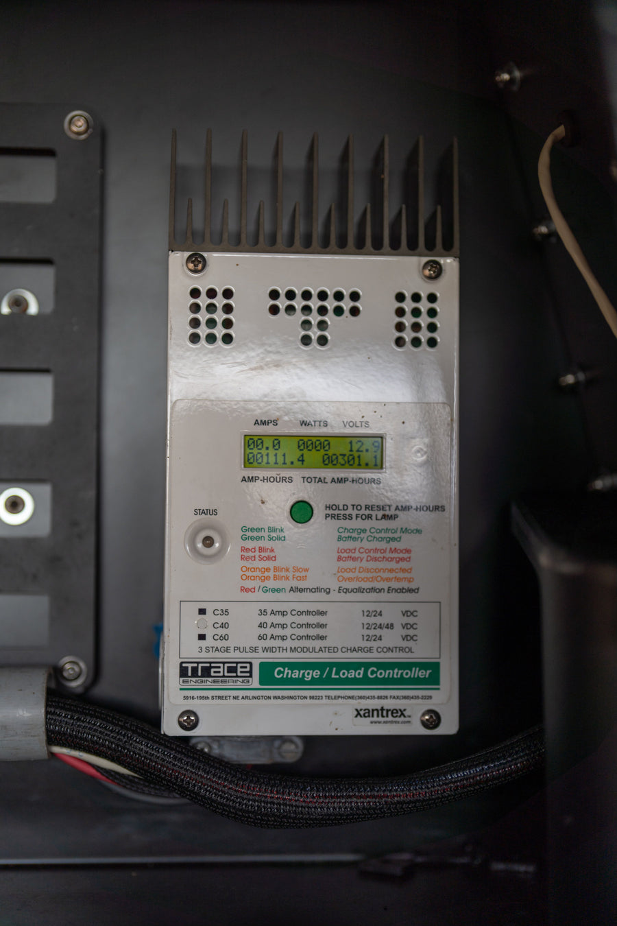 Charge controller in an RV rental displaying electrical stats like volts and amp-hours.