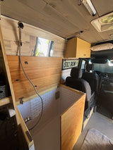 This RV rental showcases a compact, built-in shower with white subway tiles and wood paneling, perfect for mobile bathroom convenience.