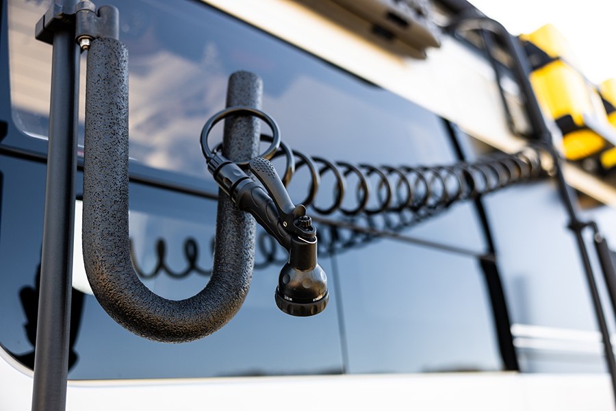  reveals a cozy bed and organized interior through its open rear doors.|Inside a comfortable RV rental: custom van conversion with bench seats — photo 2