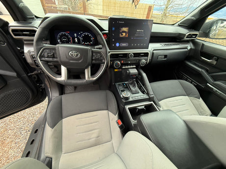Spacious Toyota Tacoma interior with digital dash, large infotainment, and comfy seats. Perfect for a rugged rv rental trip.