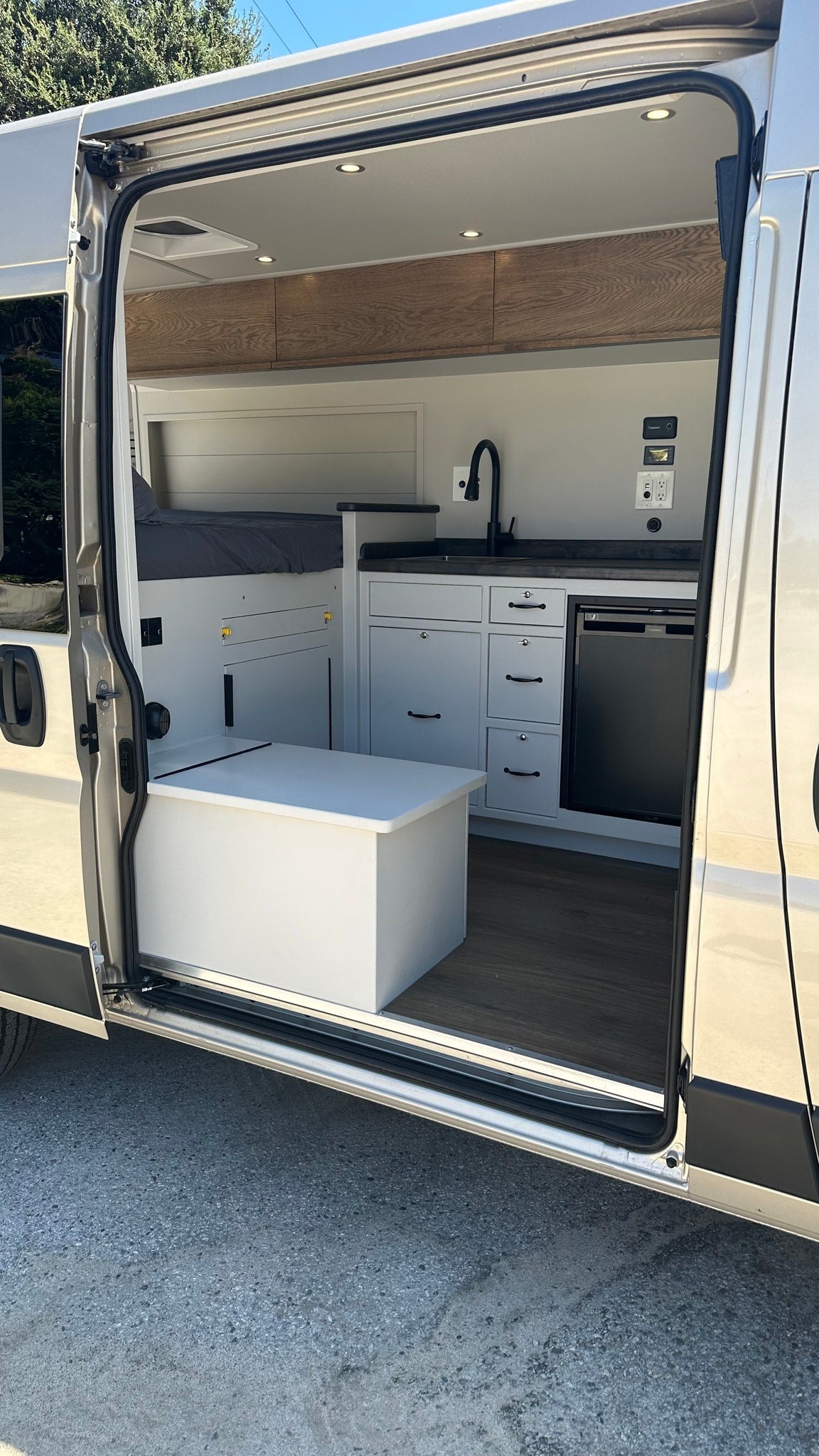  complete with a dark counter and wall-mounted switch.|RV rental van interior with open mini-fridge — photo 7