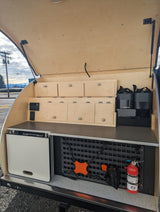 RV rental outdoor galley: organized storage with wooden drawers, power, Dometic gear, and a MOLLE panel with a fire extinguisher.
