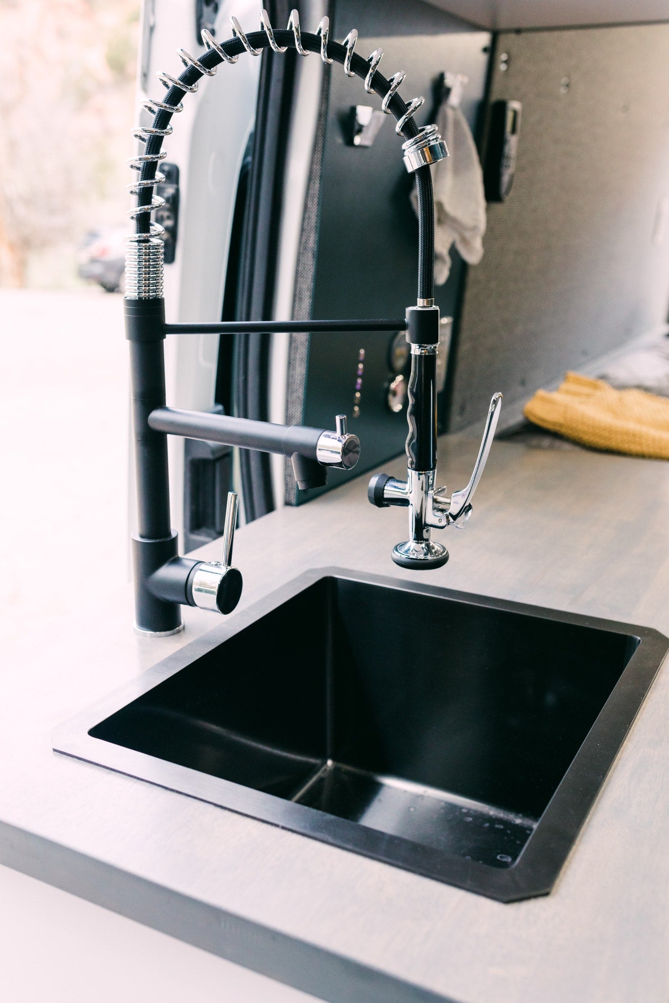 Modern RV rental kitchen featuring a sleek black sink and two sophisticated faucets, perfect for compact living. — photo 5