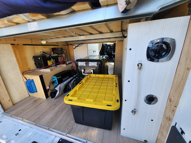RV rental under-bed setup: Renogy 2000W inverter, batteries, water system connection, and storage bins. — photo 12