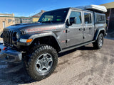 Grey Jeep Gladiator Mojave with a rooftop tent, ideal for your next rv rental adventure.