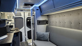 Step inside this sleek RV rental! Enjoy a compact kitchen, fridge, and cozy bench seating with overhead storage for your adventure.