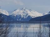 Scenic winter mountain range with reflective water & bare trees. Ideal landscape for an RV rental road trip.