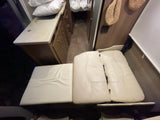 View inside an RV rental, showing a compact kitchen counter, lower cabinets, and versatile cream-colored seating cushions.