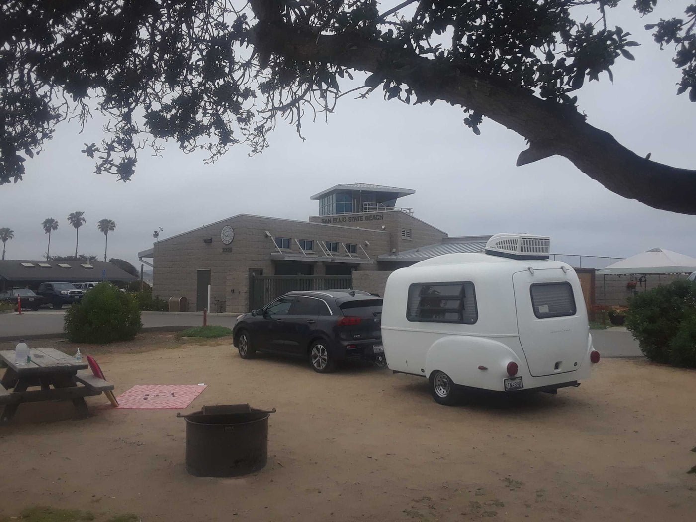  admiring the ocean view from the open back. Ideal for beach getaways and adventures.|RV rental adventure! A parent & child enjoy ocean views from their camper at Carlsbad State Beach.|Top-down view of a Happier Camper RV rental interior — photo 4