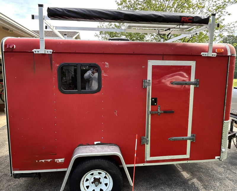 Red cargo trailer, modified with window, solar-ready roof rack, & awning for RV rental. — photo 7