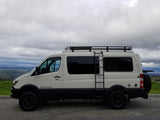 White Sportsmobile Sprinter camper van, an excellent rv rental for off-road adventures, parked with a mountain and bay view.