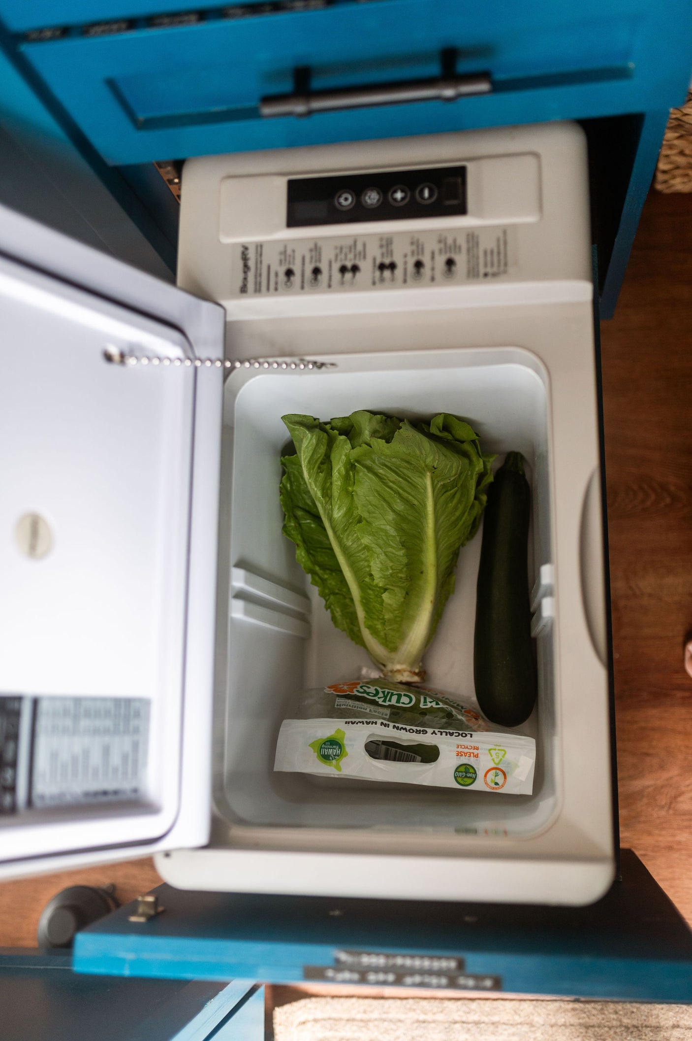 Inside an RV rental's compact fridge: fresh lettuce, zucchini, and Hawaiian cucumbers, ready for healthy meals on the go.