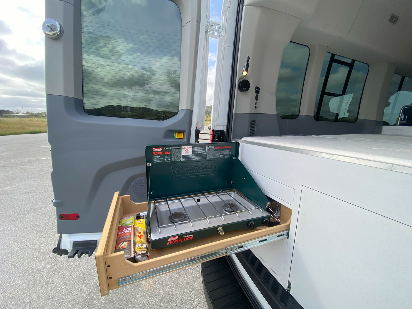 This rv rental has a pull-out Coleman propane stove with matches, ideal for convenient outdoor cooking. — photo 18