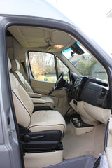Luxurious RV rental interior with cream leather seats, modern dash, and spacious front cabin.