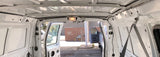 Inside a spacious white rental van, doors open, showing the unpaneled interior—perfect for an RV rental build.