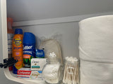 A well-stocked shelf in an RV rental, featuring essential toiletries: sunscreen, bug spray, soap