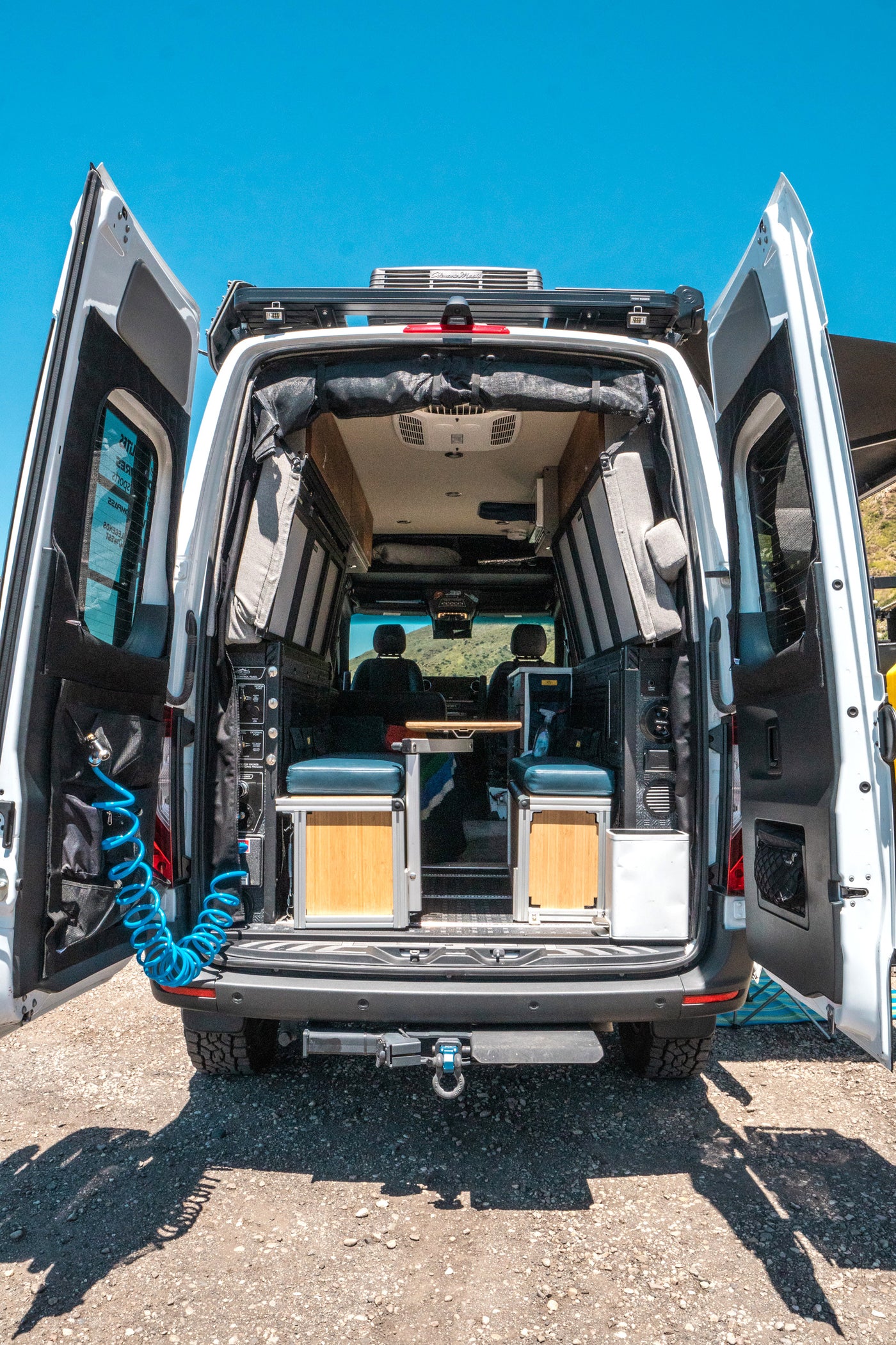 Customized RV rental camper van with open rear doors showing its well-equipped interior for road trips. — photo 10