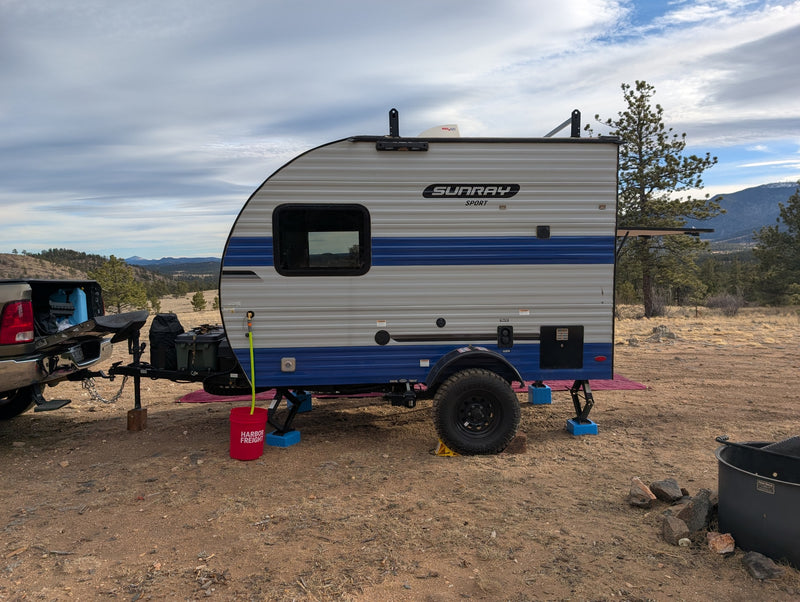This Sunray Sport RV rental is set up at a rustic campsite, ready for an outdoor adventure with mountain views. — photo 6